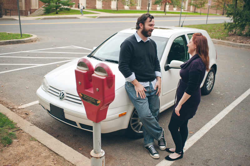 An engaged couple retells the story of their first kiss while standing in the parking lot by the Nittany Lion Shrine on the State College PSU Campus.
