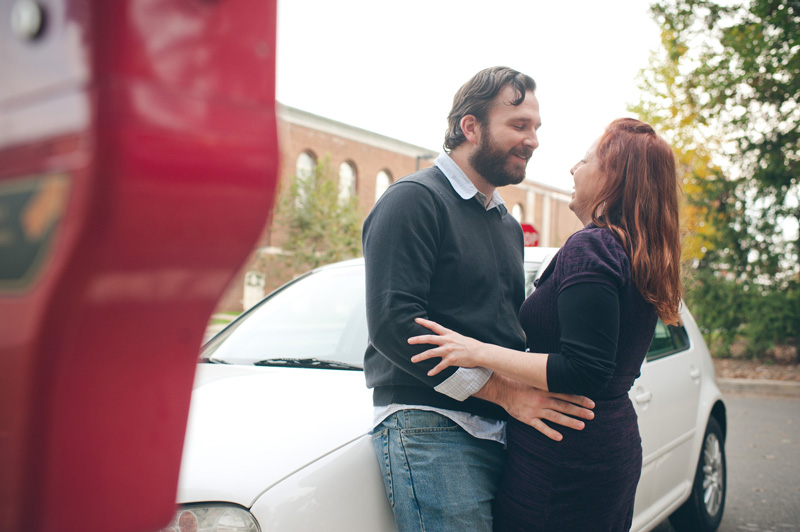 A red parking meter partially hides a young couple in love while they tell the story of their first kiss.